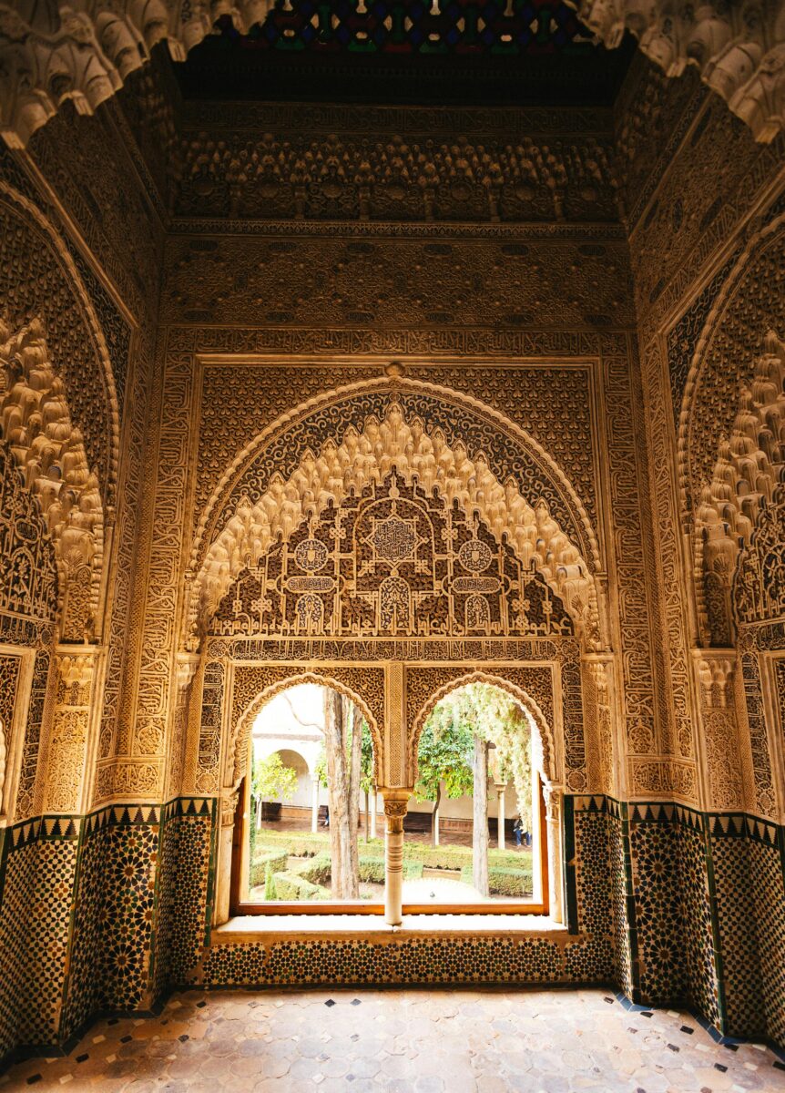 Stunning intricately carved Moorish archways inside the Alhambra Palace in Granada, Spain, showcasing Islamic art.